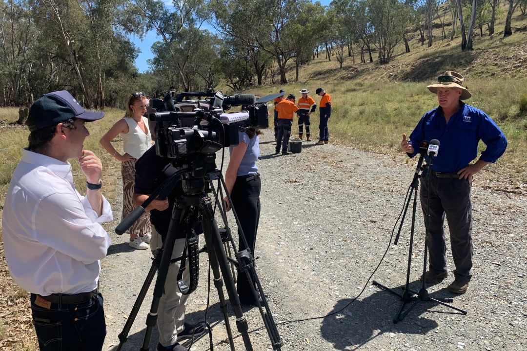 Farmer in blue shirt talking to media